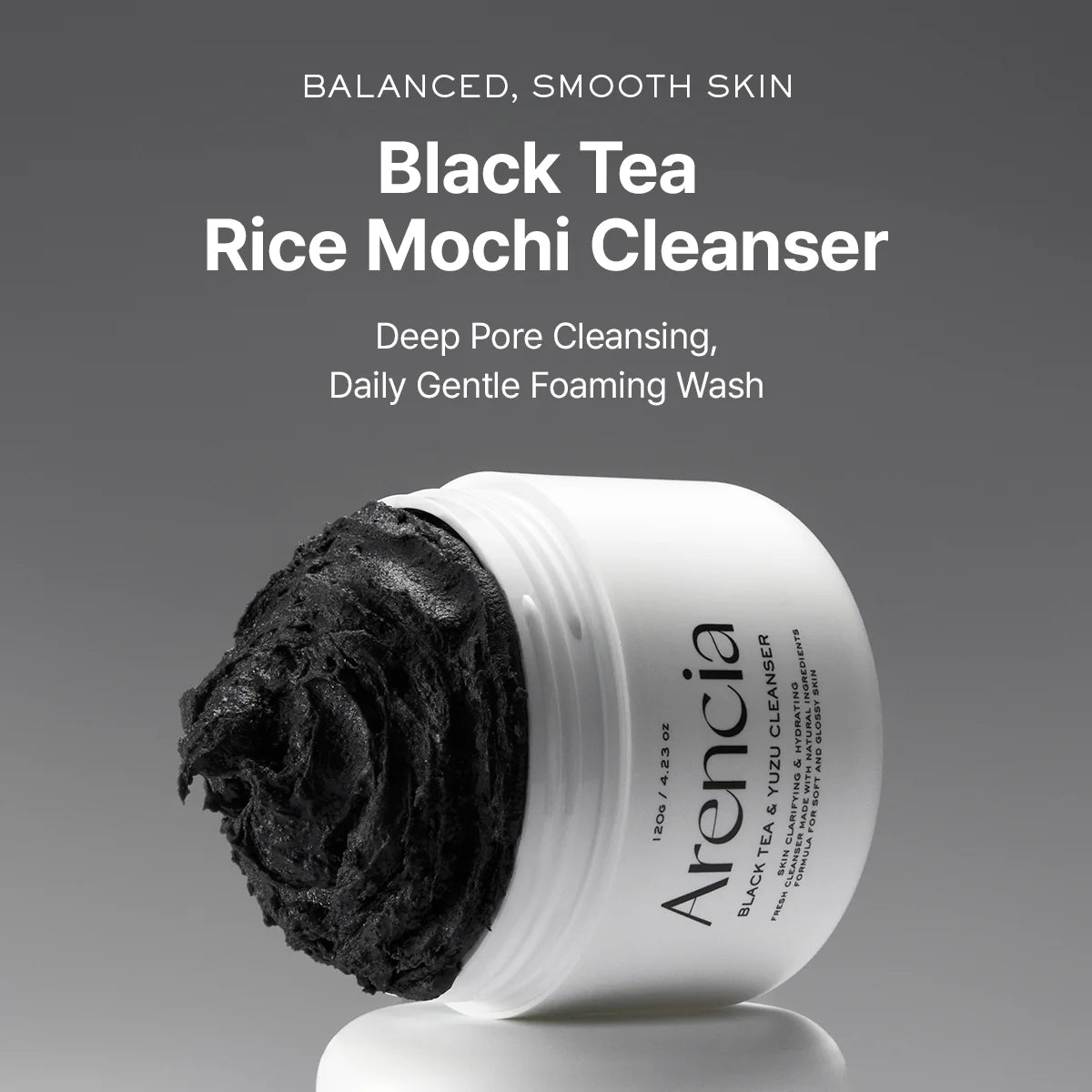 Arencia Black Tea Rice Mochi Cleanser with black scrub on a gray background